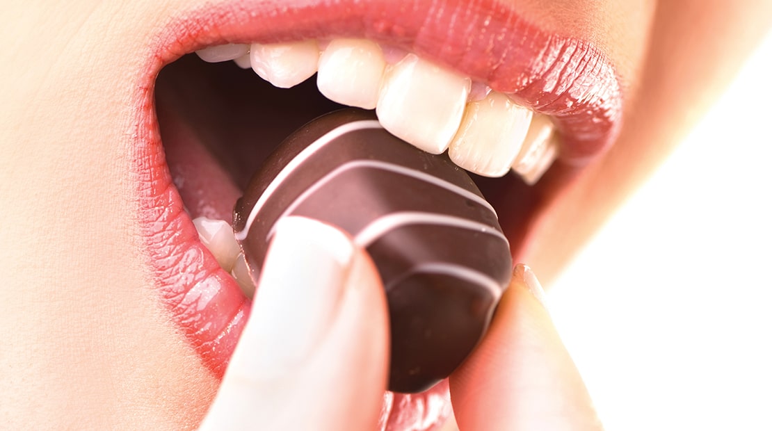 Woman biting into a chocolate - how to measure bite force